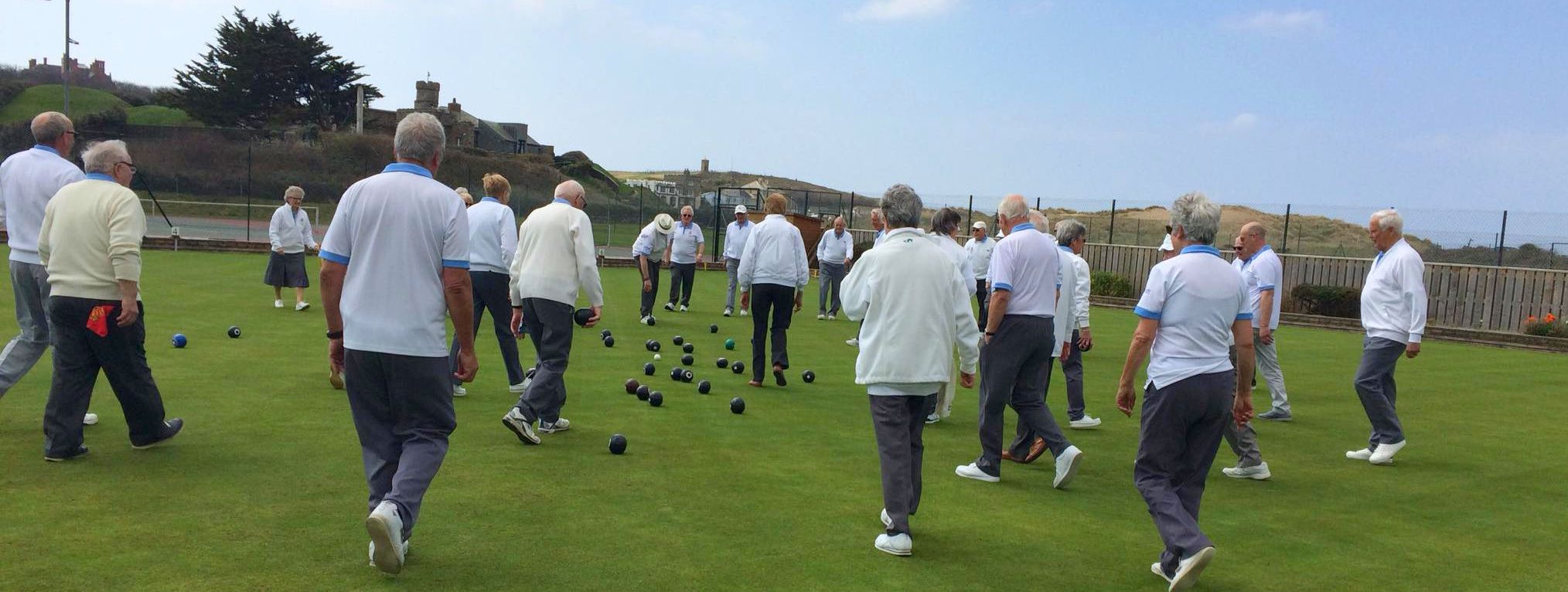 Players on the bowling green with a sea view in the background